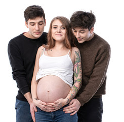 Young pregnant woman posing with two young man on a white background