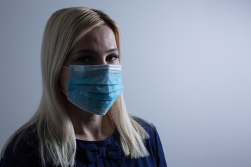 Young long-haired woman in protective medical mask