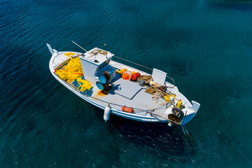 Aerial photo top view of small traditional fishing boat in tropical emerald and turquoise clear sea