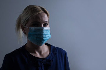 Young long-haired woman in protective medical mask
