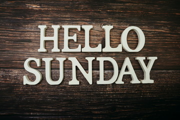 Hello Sunday alphabet letter on wooden background