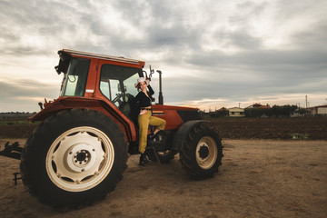 Farm girl up on the tractor after harvesting the fields