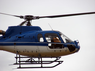 Blue helicopter flying in fog