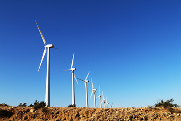 desert hill wind turbine farm bright blue sky