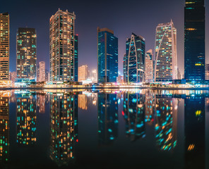 Fototapeta na wymiar Amazing architecture parallel buildings. Cloudy night sky. Luxury travel inspiration. Dubai Jumeirah Lake Towers.