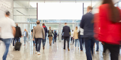 Blank advertising poster in hall of a trade fair about people