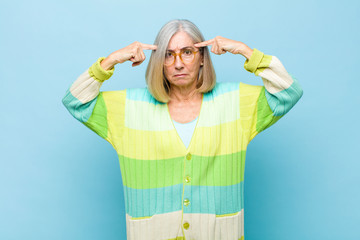 senior or middle age pretty woman with a serious and concentrated look, brainstorming and thinking...