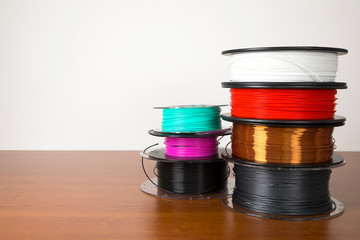 3D printing filament reels isolated over white and wooden background
