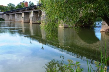 Fototapeta na wymiar An old bridge reflected on the river