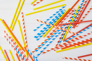 Colorful paper straws for party on the wooden background. Top view.