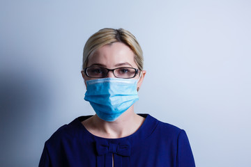an attractive young woman wears a paper face mask to protect herself from the H1N1 Virus, isolated on white, with room for your text