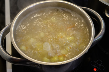 Chicken soup with potato and cabbage in the pan. Slow shutter speed.