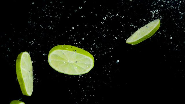 green lemon splashing into water- slow motion