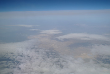 View from the plane window to the clouds and the earth