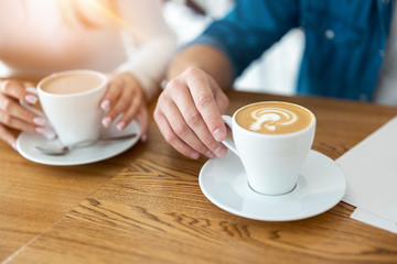 man and woman holding cups of hot coffee, closeup