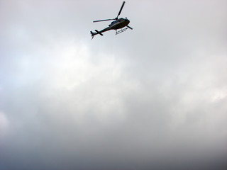 Helicopter flying in sky with clouds
