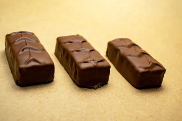 Three chocolate bars on a beige background