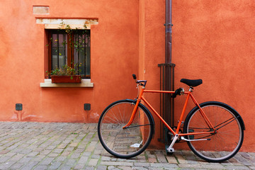 Fototapeta na wymiar Red bicycle near old house in Rimini