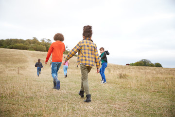 Rear View Of Group Of Children On Outdoor Activity Camping Trip Walking Up Hill
