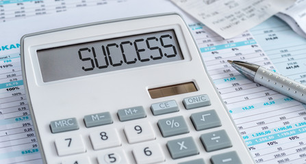 A calculator with the word Success on the display