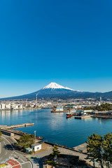 冬の快晴の日、静岡県の田子の浦港から富士市の工業地帯と富士山の眺め。
