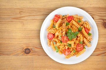 Spaghetti pasta with tomatoes and parsley on  table.