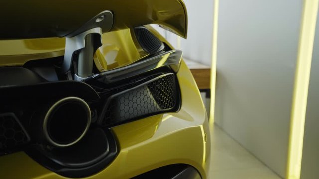 Modern yellow sport supercar exhaust system pipes close up