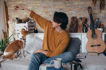 young man playing with his dog at home