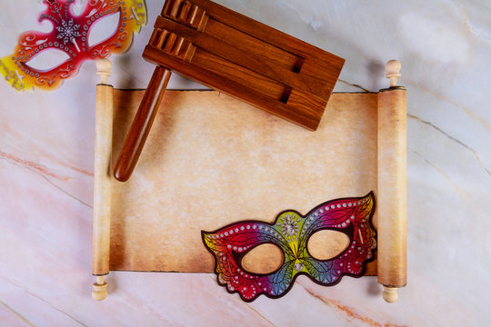 Papyrus roll with Purim masks and noisemaker for fastival.