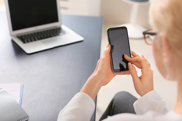 Young woman with mobile phone in office