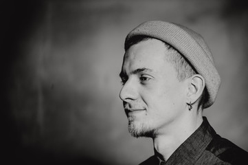 Monochrome black and white photo. Portrait of puncker bearded man in hat. Book concept.