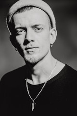 Monochrome black and white photo. Portrait of puncker bearded man in hat. Book concept.
