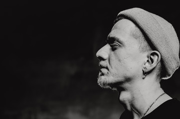 Monochrome black and white photo. Portrait of puncker bearded man in hat. Book concept.
