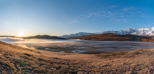 Autumn mountains at sunrise in the fog