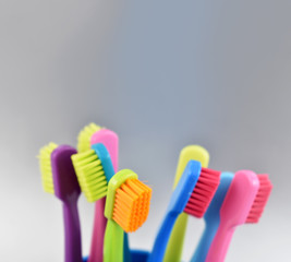 Different multi-colored toothbrushes stock images. Morning hygiene concept. Bathroom accessories images. Toothbrush on a silver background. Toothbrush on a light background with copy space for text