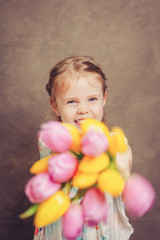 Fototapeta na wymiar little girl holding tulips