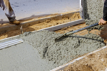 Construction worker pour cement for sidewalk in new residential home