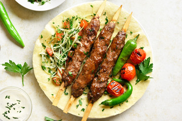 Adana Kebab with fresh vegetables on flatbread