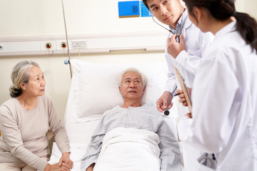 Obraz na płótnie Canvas senior asian patient being check by doctors in hospital ward