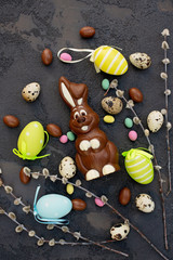 Delicious chocolate easter bunny and eggs on a stone background. Happy easter.