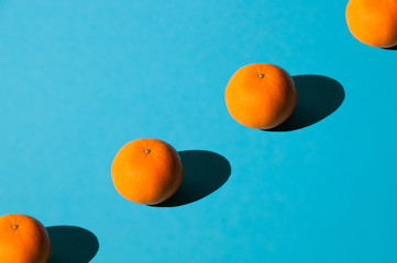Juicy tasty tangerines. Lots of fruit on blue background, space to insert text