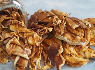 Dried melon chips in a glass jar on a wooden background. Home cooking. Natural healthy product, place for text.