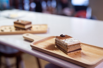 chocolate cake on wooden plate in mini cafe