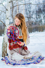 A young blonde woman in traditional Slavic clothing holds the symbol of generations - the Family tree. a ritual ancestral connection