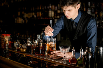 Bartender makes a cocktail over the bar counter