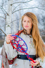 A young blonde woman in traditional Slavic clothing holds the symbol of generations - the Family...