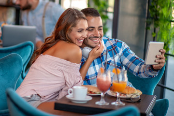 Young couple having breakfast in city cafe