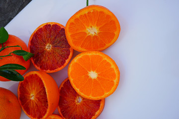 Platter of orange and mandarosa red clementines cut in half on a white platter