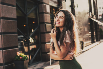 Beautiful smiling woman walking in the city on summer day.