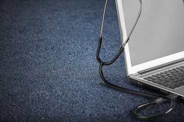 Medical doctor's stethoscope on a modern laptop